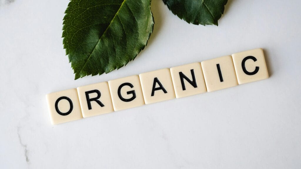 pexels-photo-3669640-3669640 Close-up of 'ORGANIC' spelled with tiles next to a leaf on a marble surface.